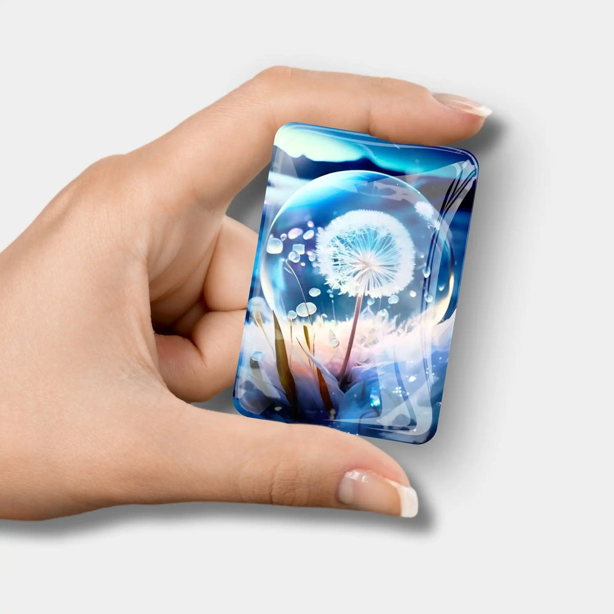 Diamond Painting Cover Minder mit blauem Pusteblume Eiskristall Motiv in einer Hand gehalten