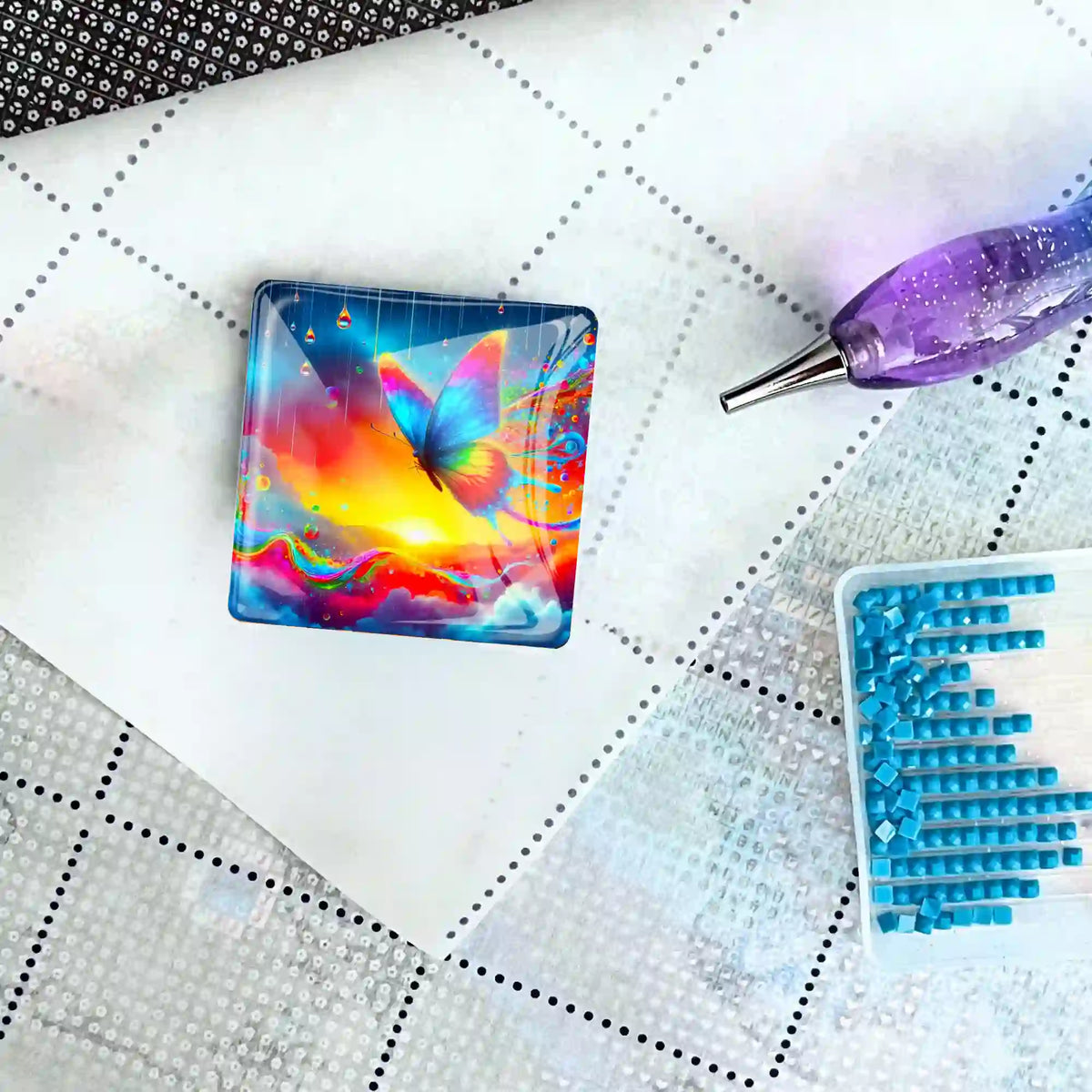 Quadratischer Diamond Painting Cover Minder mit Schmetterling-Motiv auf einer Leinwand mit Stift und Glitzersteinen