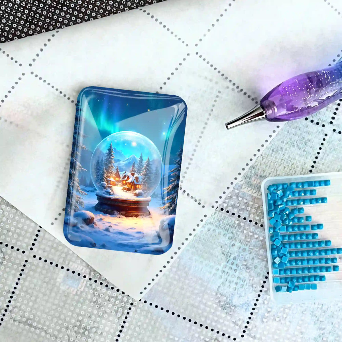 Glas Coverminder mit Schneekugel-Motiv auf einer Diamond Painting Leinwand mit Glitzersteinen und Stift