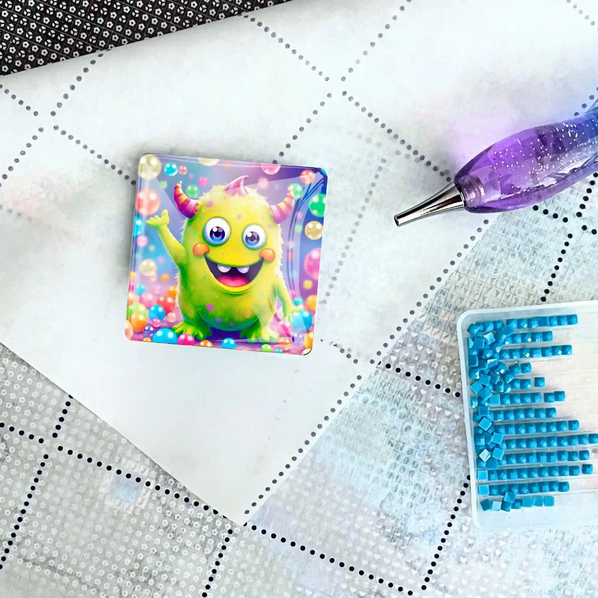 Quadratischer Cover Minder mit Monster-Motiv auf einer Diamond Painting Leinwand mit Stift und blauen Diamant-Steinen
