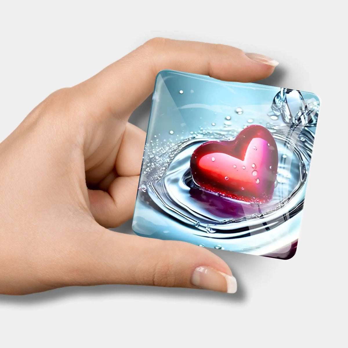 Quadratischer Diamond Painting Cover Minder Waterheart mit rotem Herz-Motiv in einer Hand gehalten