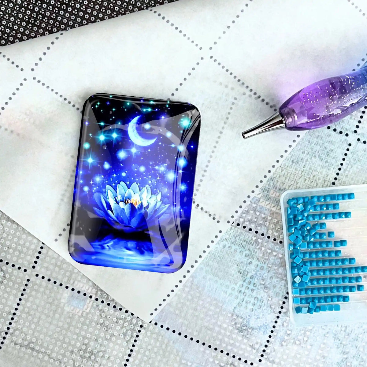 Magnetischer Cover Minder mit blauer Seerose als Zubehör für Diamond Painting auf einer Leinwand mit Glitzersteinchen.