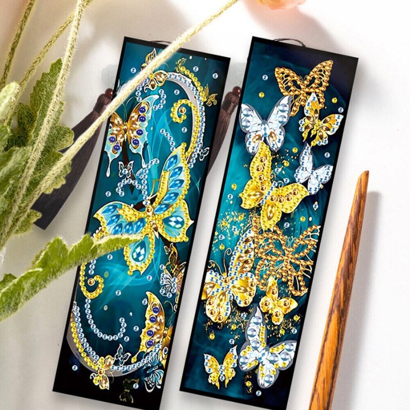 Diamond Painting Lesezeichen 2er-Set mit glitzernden Schmetterlingen und floralen Elementen auf dunkelblauem Grund