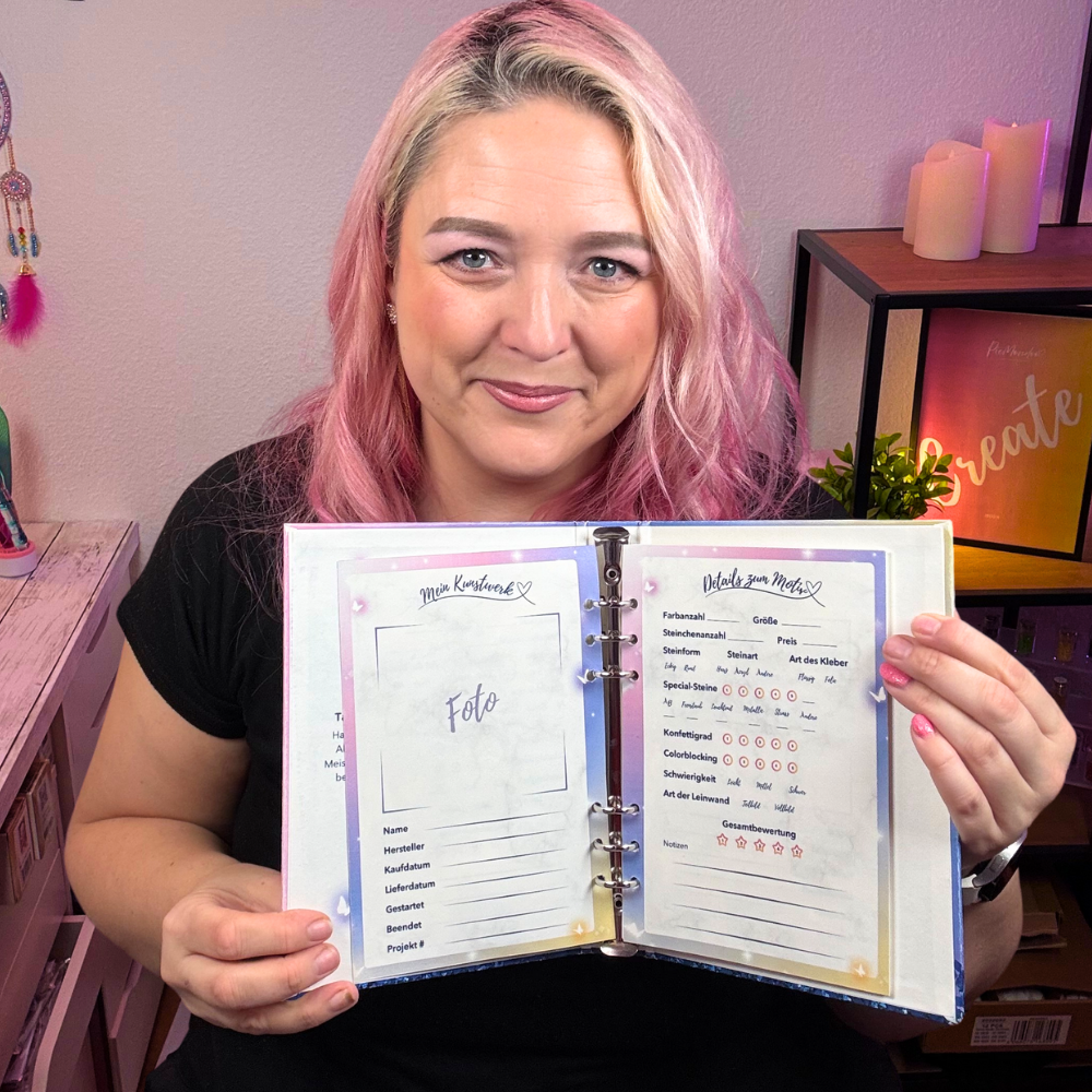Frau hält ein aufgeschlagenes Diamond Painting Tagebuch zur Erfassung von Motiven und Projektfortschritten