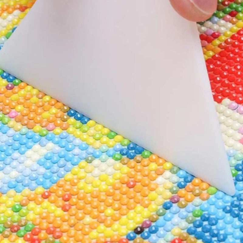 Weißer Korrektur Schieber richtet bunte Diamanten auf einem 5D Diamond Painting Set gerade aus