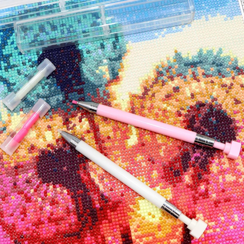 Diamond Painting Stift Twist Set mit Wachsspitzen auf einer bunten Leinwand mit 5D Diamanten