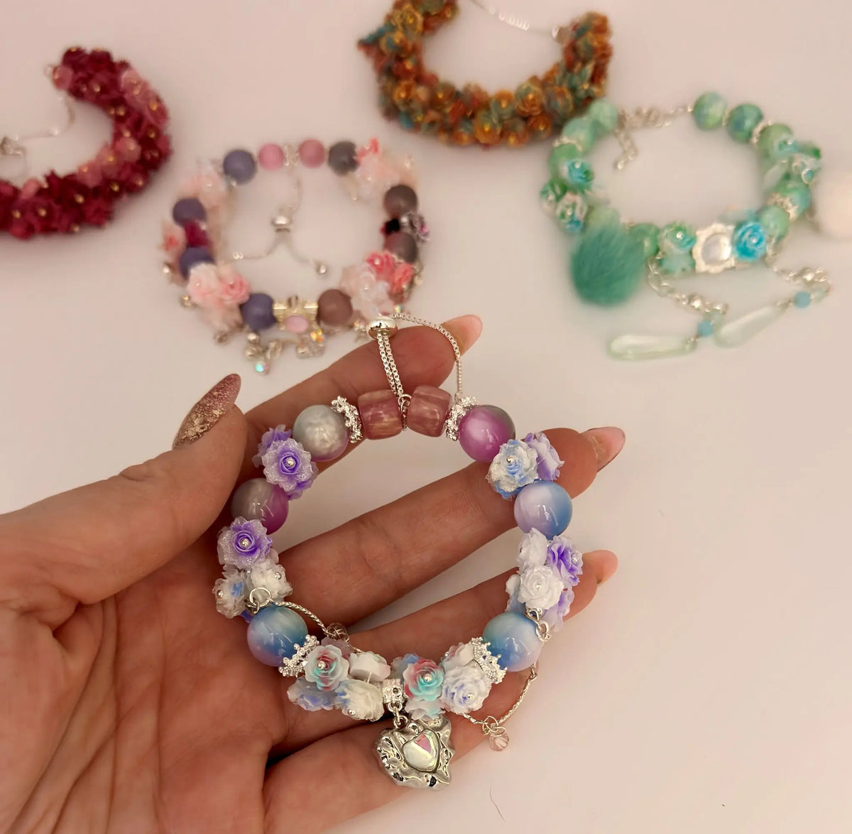 Hand hält buntes Soft Flower Armband mit Blumen-Perlen als stylisches DIY-Schmuck Geschenk von Picmondoo