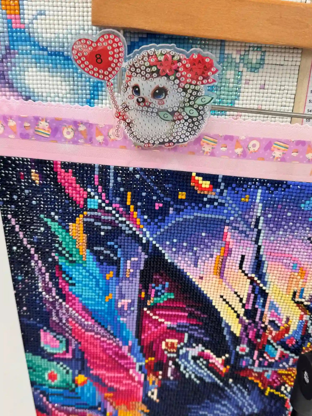 Süßer Diamond Painting Igel-Magnet für Kinder über einem bunten, mit glänzenden Diamanten besetzten Diamond Painting Bild