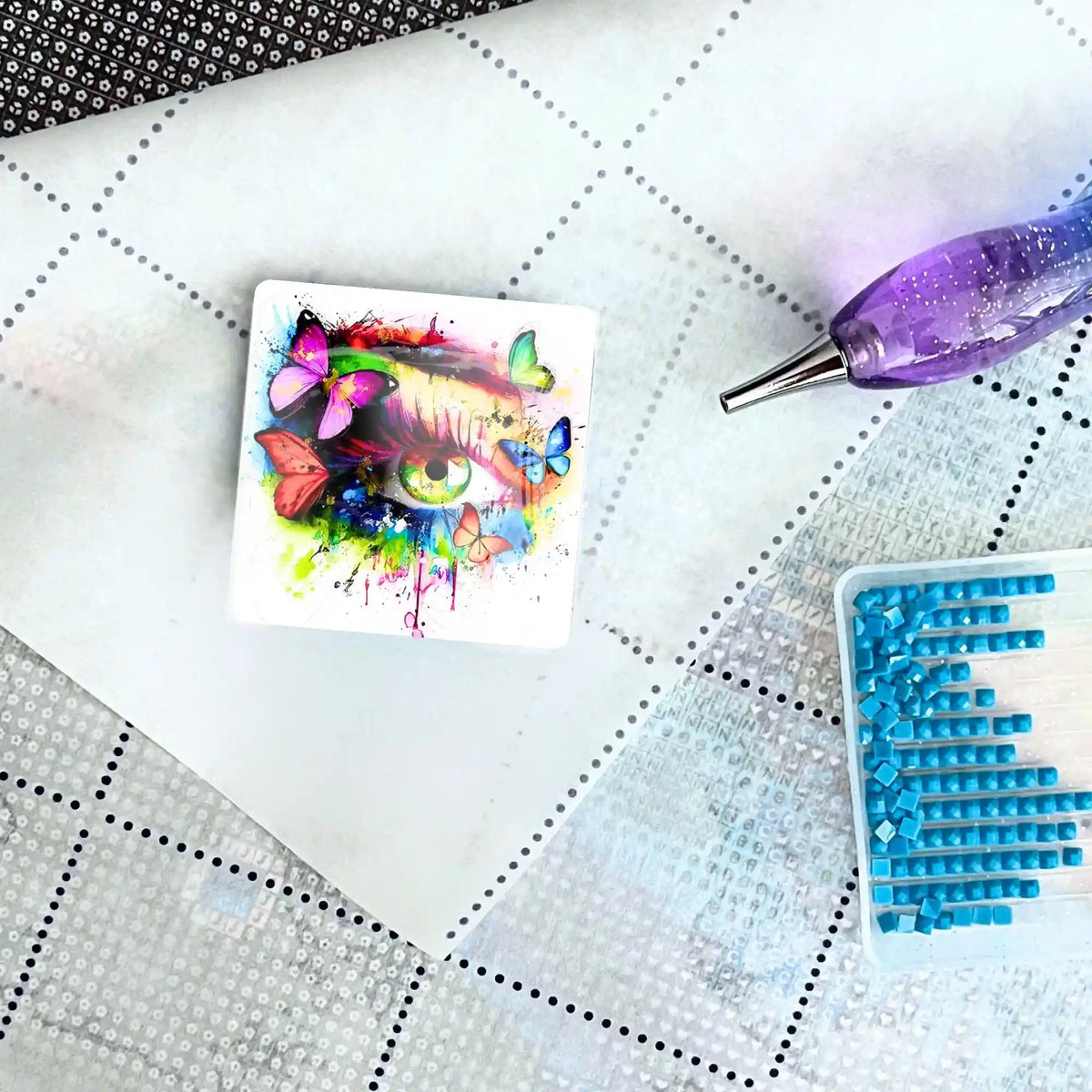 Magischer Diamond Painting Cover Minder mit Schmetterlings-Augen-Motiv auf einer Leinwand mit Stift und Glitzersteinen