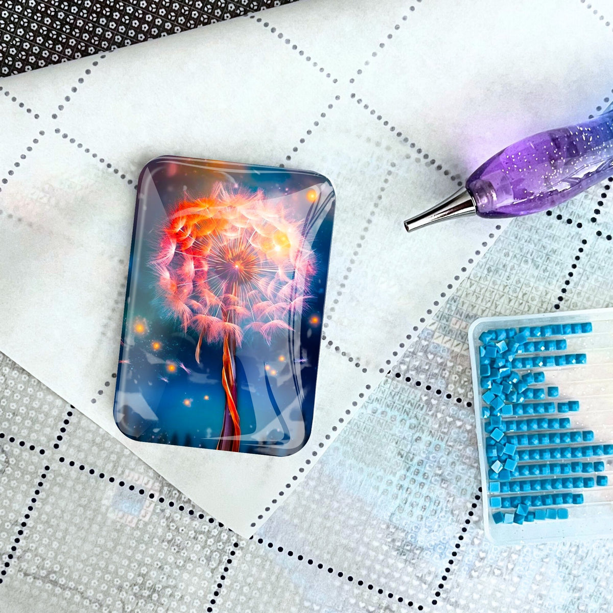 Magnetischer Glas-Cover Minder Fly away by Night für Diamond Painting mit Pusteblumen-Motiv auf einer Arbeitsmatte.