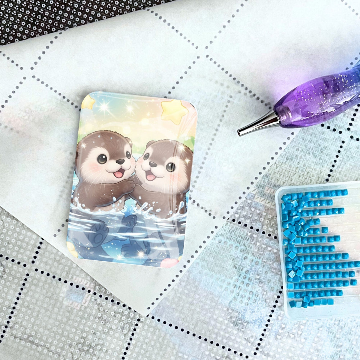 Glas Cover Minder mit Otter Motiv als Magnet-Halter für Diamond Painting Zubehör auf einer Leinwand.