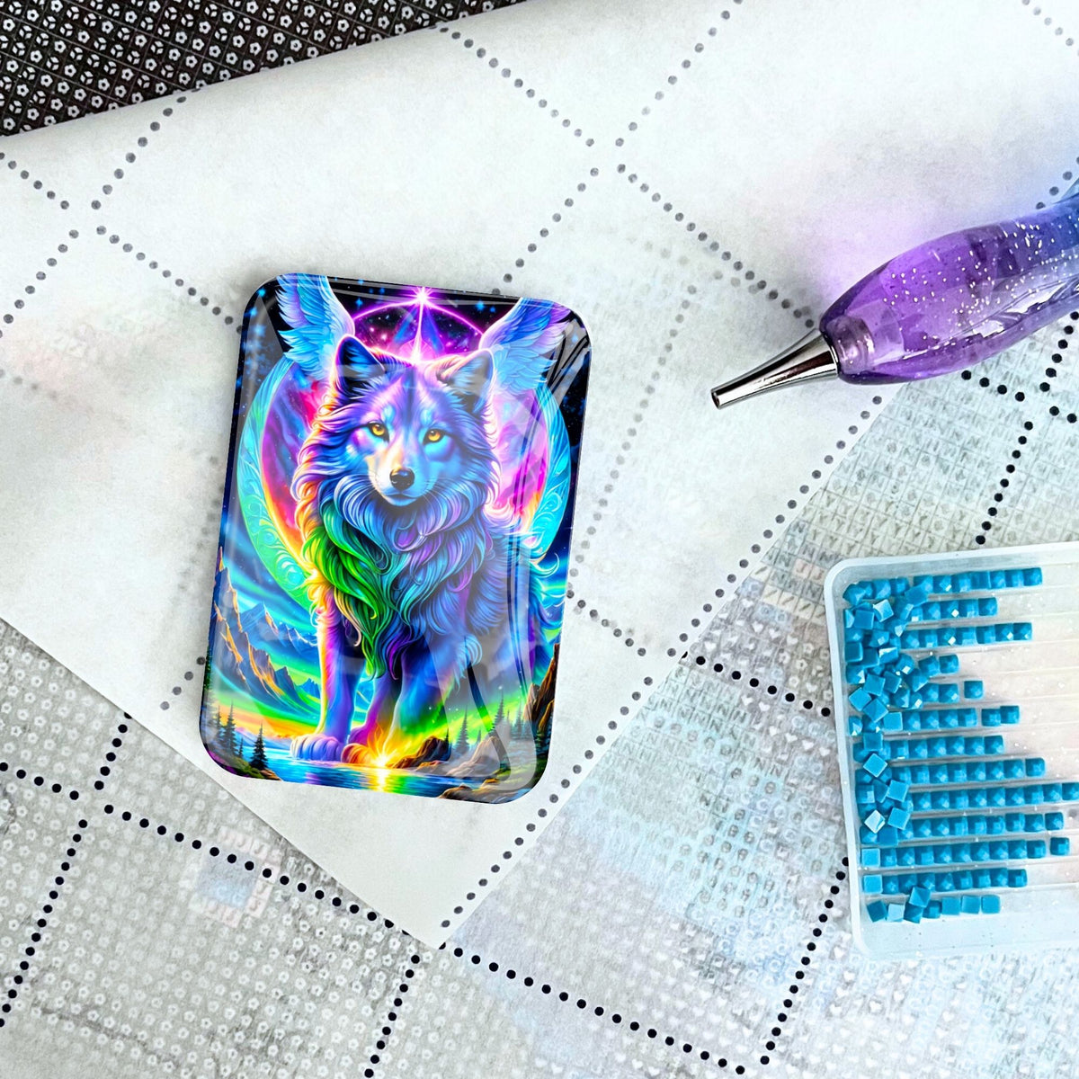 Magischer Cover Minder mit Wolf-Motiv für Diamond Painting auf einer Leinwand mit Werkzeug und blauen Steinchen