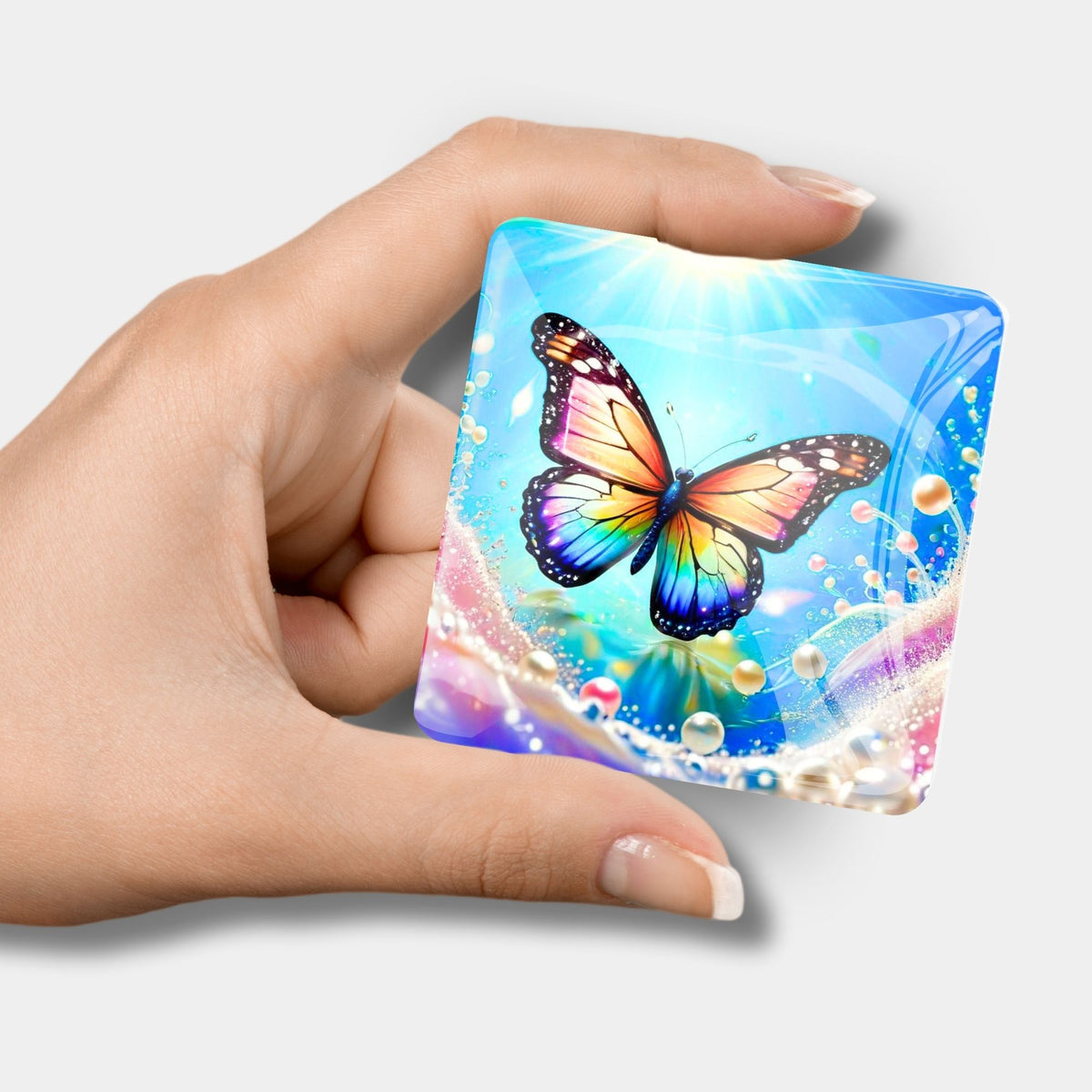 Quadratischer Diamond Painting Cover Minder mit Schmetterling-Motiv und Perlen in einer Hand gehalten
