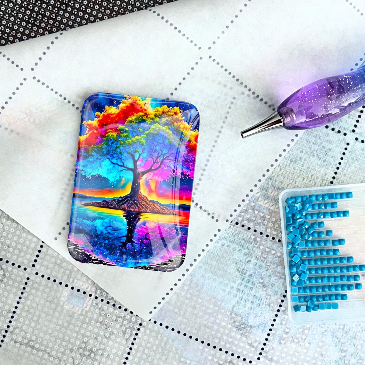 Bunter Rainbow Tree Cover Minder aus Glas als praktisches Zubehör für Diamond Painting auf einer Leinwand.