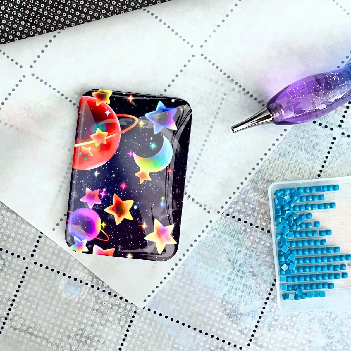 Bunter Universum Cover Minder aus Glas auf Diamond Painting Leinwand mit Stift und blauen Diamant-Steinen