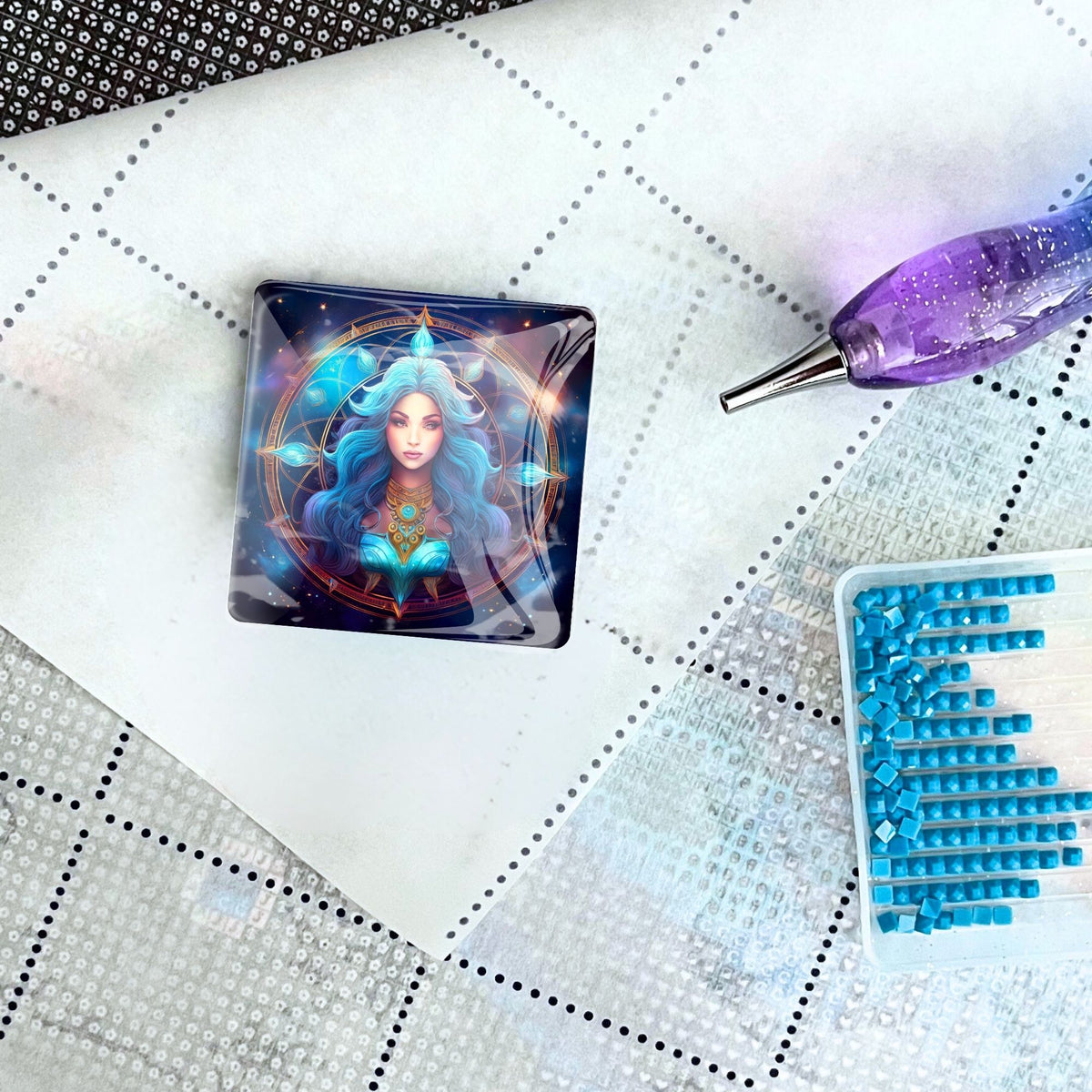 Magischer Sternzeichen Jungfrau Cover Minder aus Glas auf einer Diamond Painting Leinwand mit Stift und blauen Steinen.