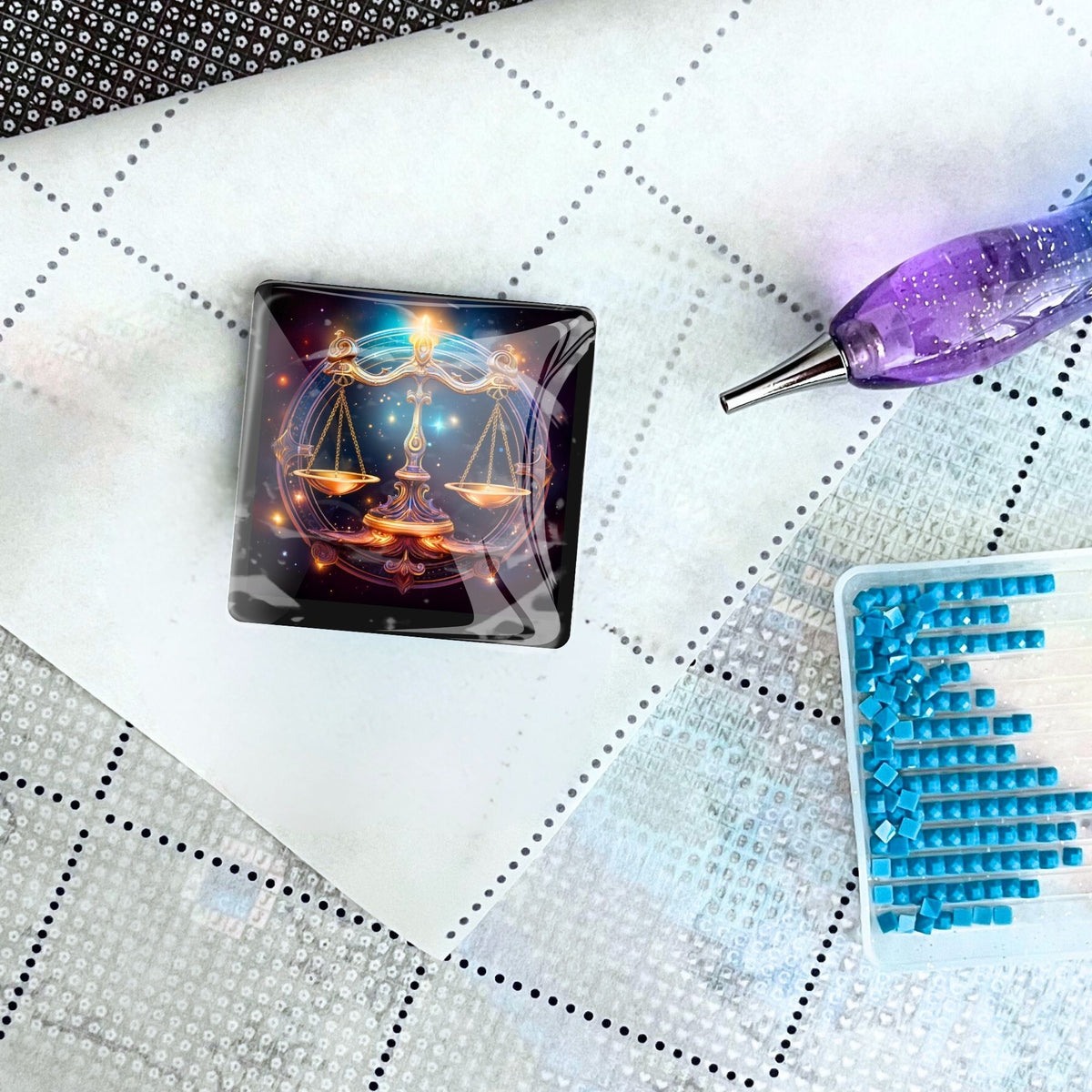 Diamond Painting Cover Minder mit Sternzeichen Waage Motiv auf einer Leinwand mit Stift und Glitzersteinen