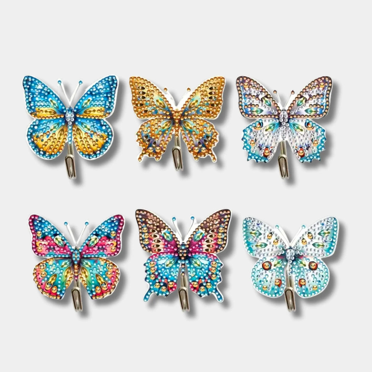Sechs bunte Diamond Painting Wandhaken mit funkelnden Schmetterlingsmotiven als DIY-Dekoration für das Zuhause