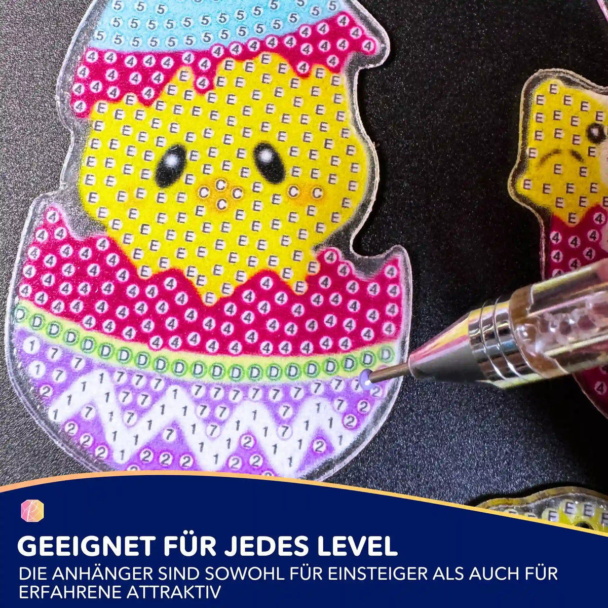 Diamond Painting Oster-Anhänger mit Küken-Motiv, in Arbeit mit Diamond Painting Stift für kreative Osterdeko.