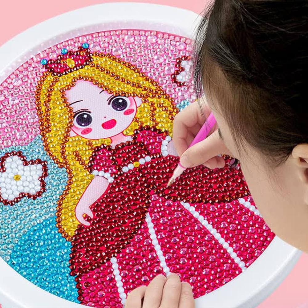 Kind setzt funkelnde Steine auf ein rundes Diamond Painting Set mit Prinzessinnen-Motiv in einem weißen Rahmen