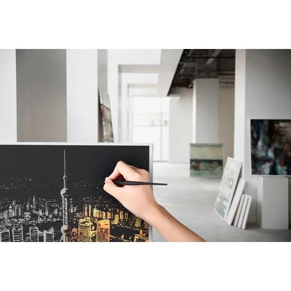 Hand beim Scratch Painting: Freilegen einer leuchtenden Skyline-Grafik aus dem 4er DIY Set für kreative Kunstwerke.