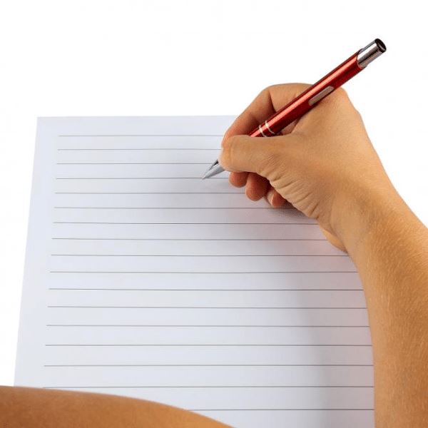 Hand schreibt mit Stift in ein Diamond Painting Notizbuch für persönliche Glückwünsche als kreatives DIY Hobby.