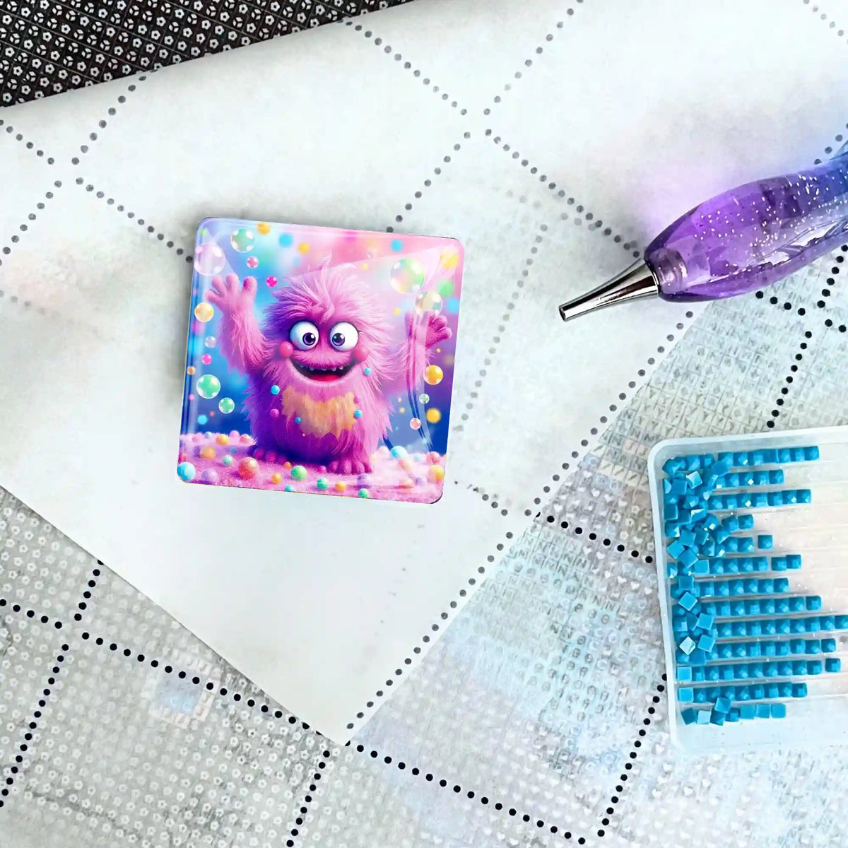 Quadratischer Diamond Painting Cover Minder Motiv Eckbert auf einer Leinwand mit glitzerndem Stift und blauen Steinchen