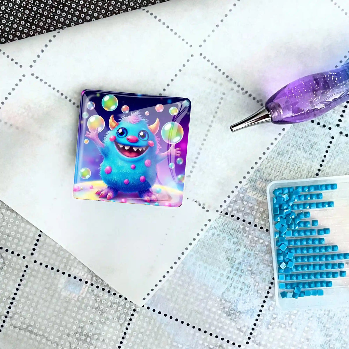 Quadratischer Diamond Painting Cover Minder mit süßem Monster-Motiv und Seifenblasen auf einer Leinwand