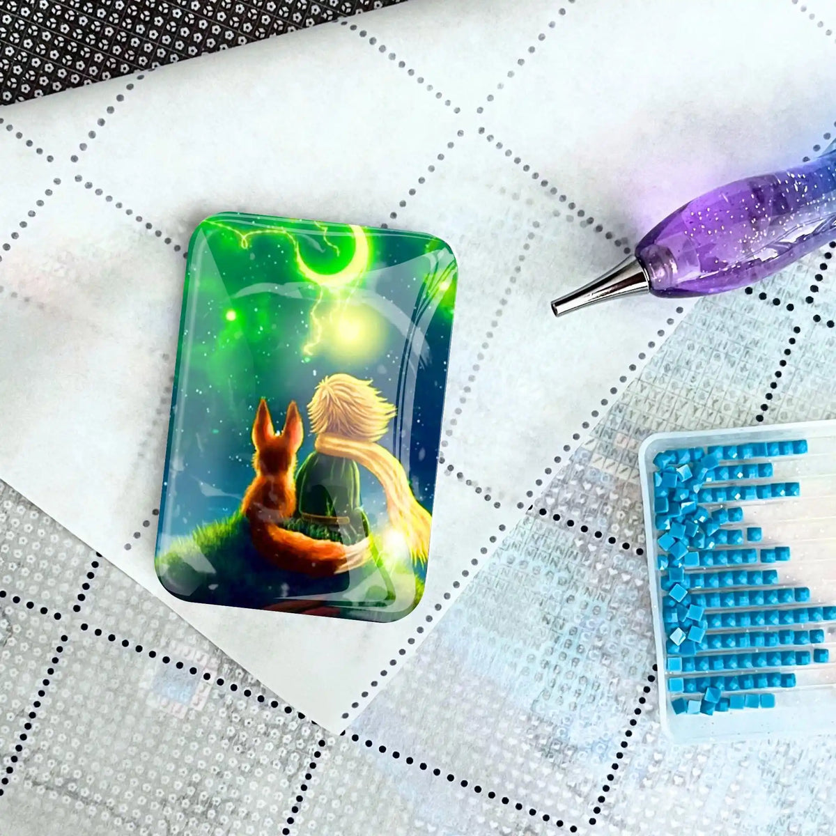 Magischer Cover Minder mit kleiner Prinz Motiv auf Diamond Painting Leinwand mit Glitzersteinen und Applikator-Stift.