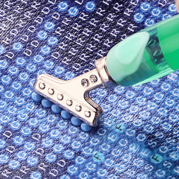 Ergonomischer Diamond Painting Stift mit Mehrfachaufsatz beim Setzen von blauen Diamanten auf einer Leinwand.
