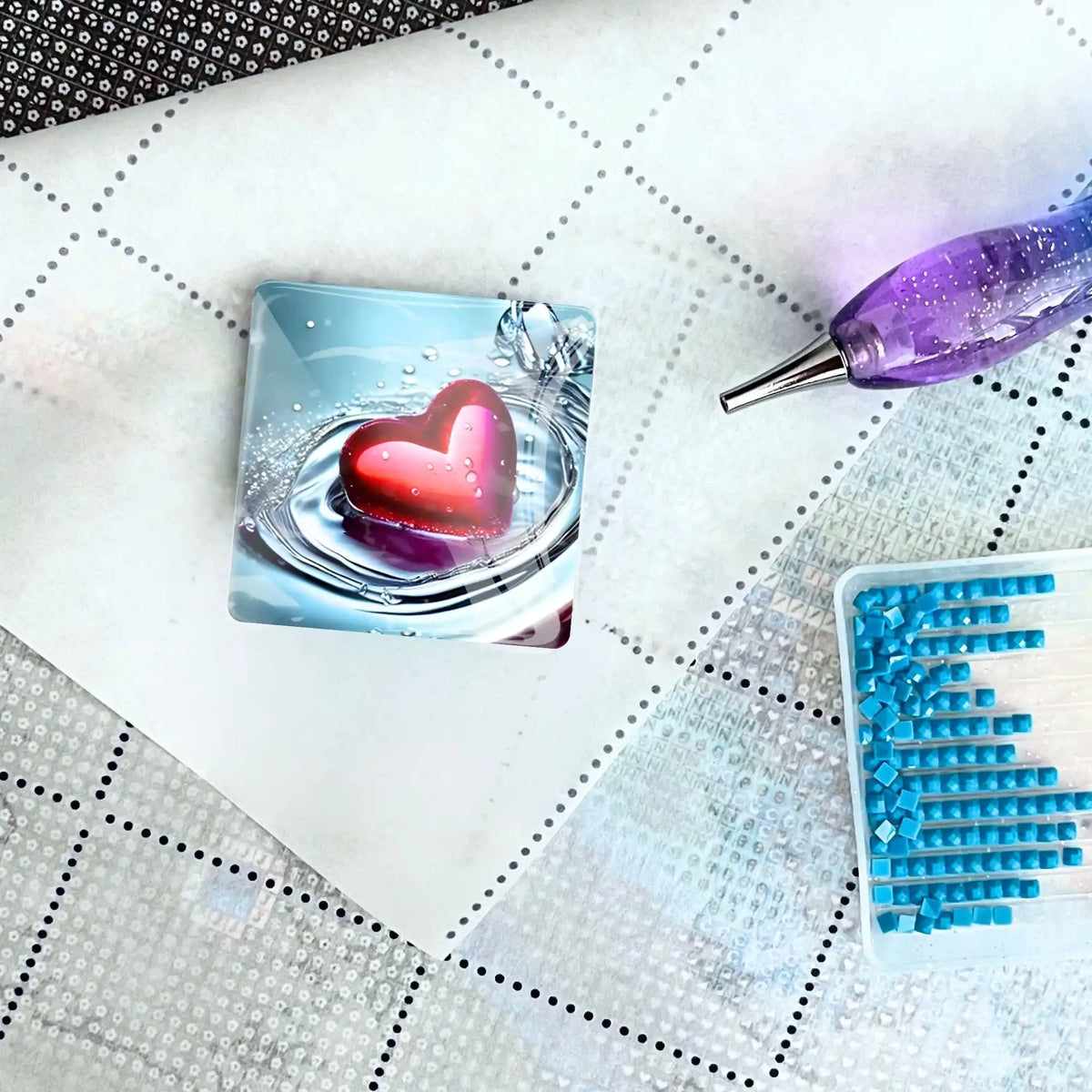 Quadratischer Diamond Painting Cover Minder mit Waterheart Motiv auf Leinwand mit Glitzer-Stift und blauen Steinchen