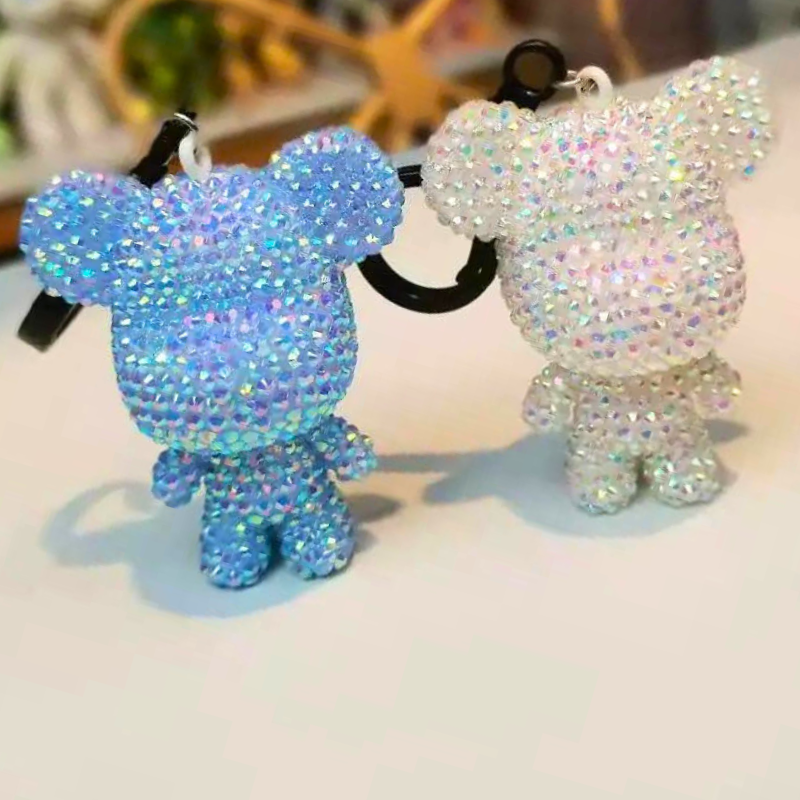 Zwei Diamond Painting Schlüsselanhänger als glitzernde Bären in Blau und Weiß mit funkelnden Schmucksteinen
