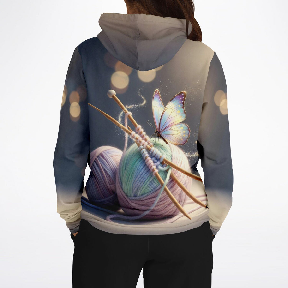 Dreamer Hoodie mit Strick-Motiv, Wollknäuel, Stricknadeln und leuchtendem Schmetterling, ideal für DIY-Fans.