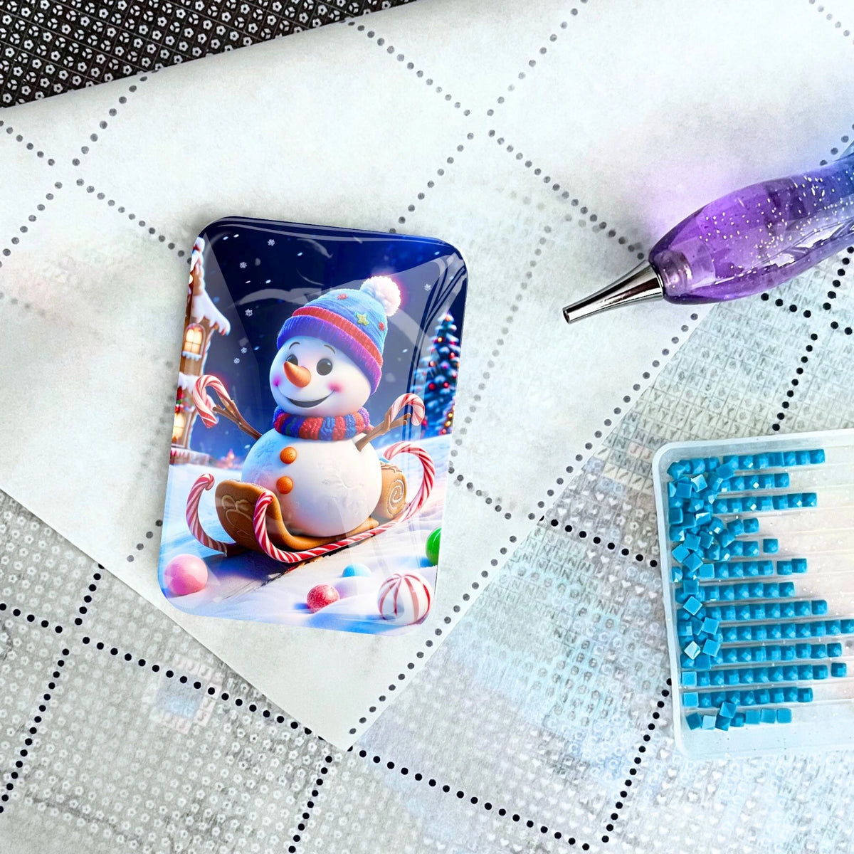 Magnetischer Coverminder für Diamond Painting mit Schneemann-Motiv auf einer Leinwand mit Stift und Glitzersteinen