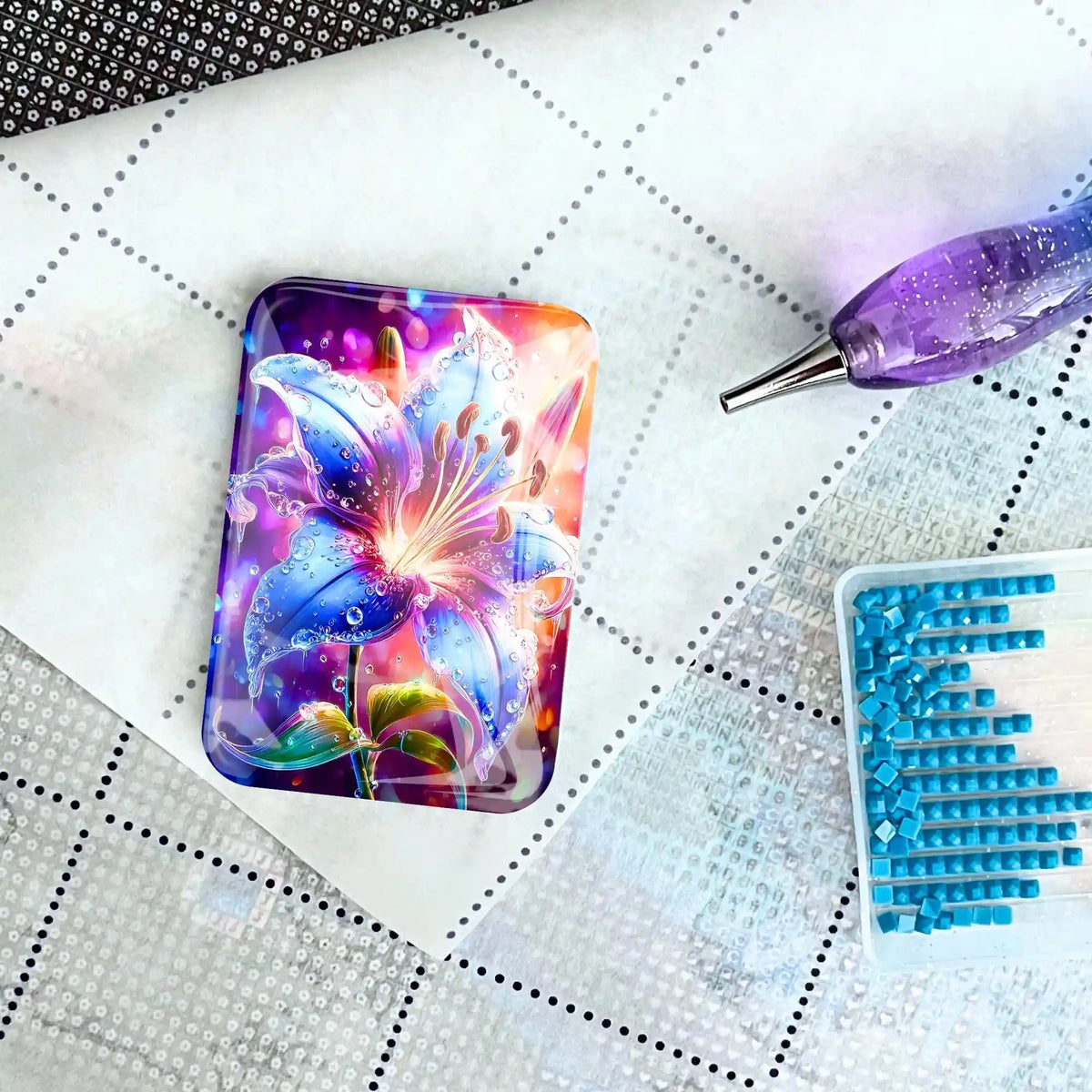 Magischer Cover Minder Regenlied mit Lilienmotiv als Zubehör für Diamond Painting auf einer Leinwand mit Applikatoren.