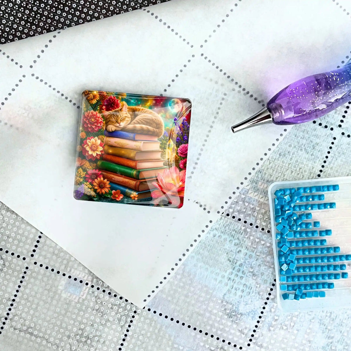 Diamond Painting Cover Minder Bücherträumerei aus Glas mit Katze auf Buchstapel neben Steinen und Stift