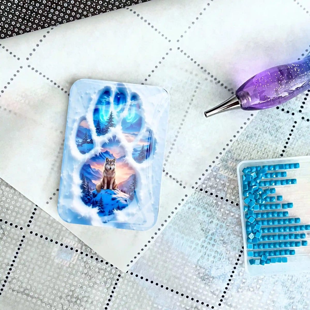 Glas Cover Minder mit Wolf-Motiv auf einer Diamond Painting Leinwand mit Glitzer-Stift und blauem Steinchen-Schälchen
