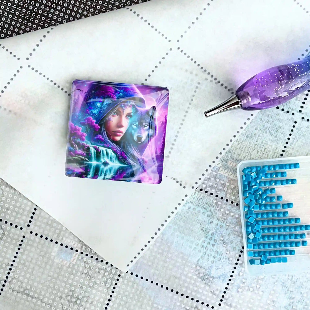 Eleonora and the Wolf Cover Minder aus Glas auf einer Diamond Painting Leinwand mit Stift und blauen Diamanten.