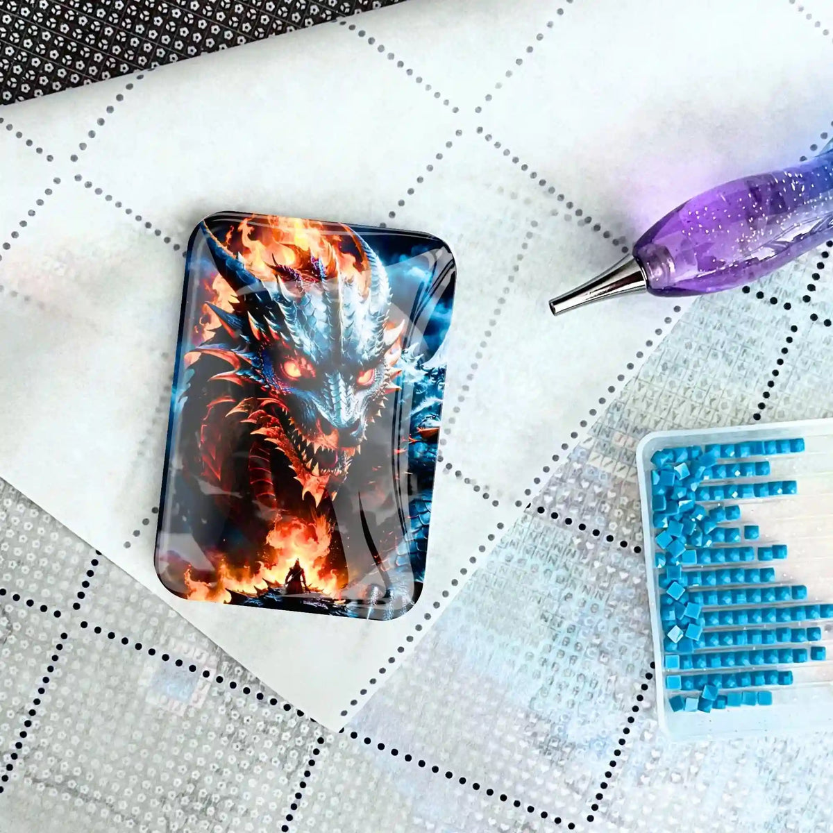 Magischer Drachen-Coverminder aus Glas für Diamond Painting auf einer Leinwand platziert mit Stift und Glitzersteinen