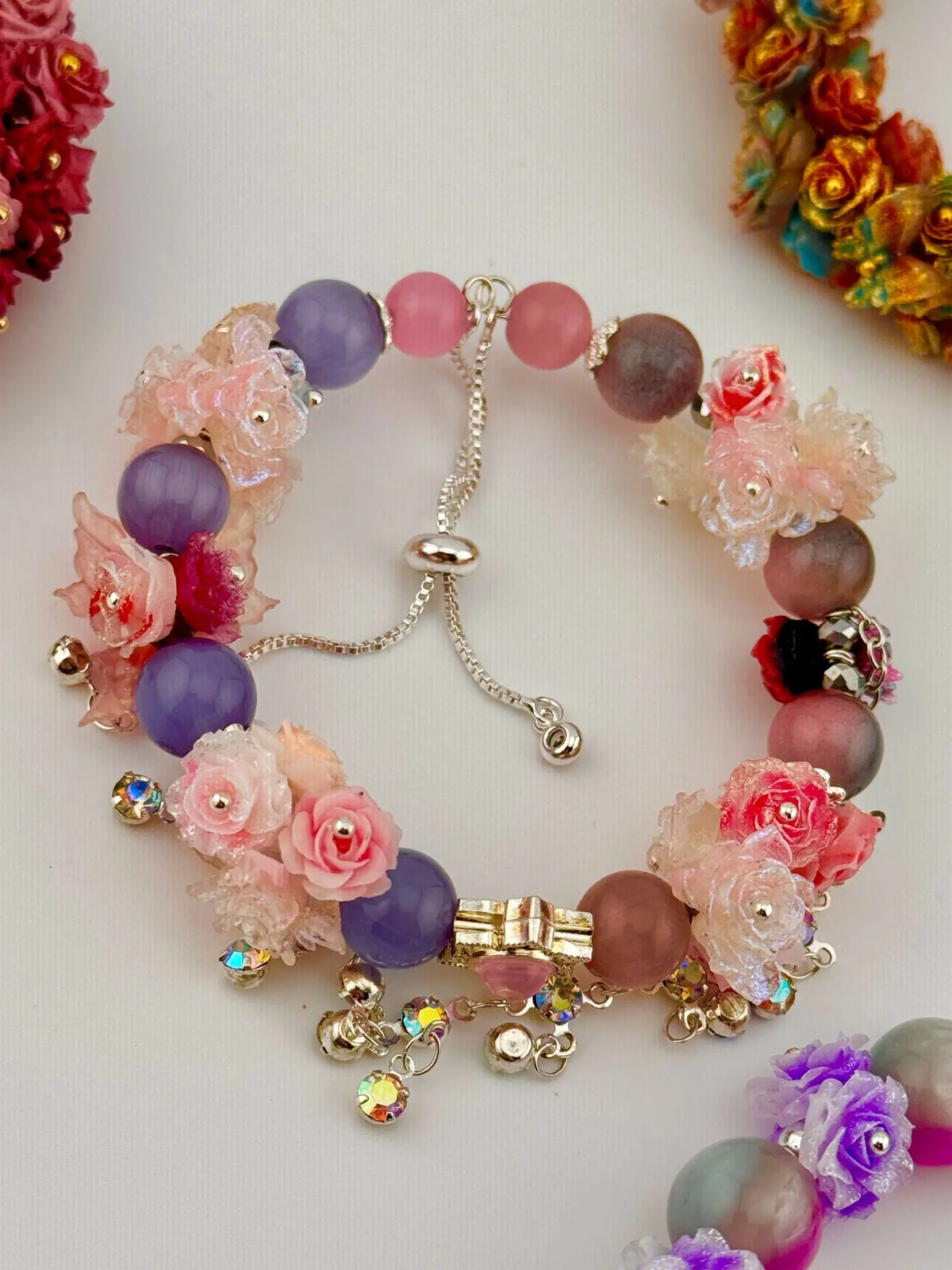 Elegantes Damenarmband mit Blumen-Design, bunten Perlen und glitzernden Anhängern als besonderes DIY Schmuck Geschenk