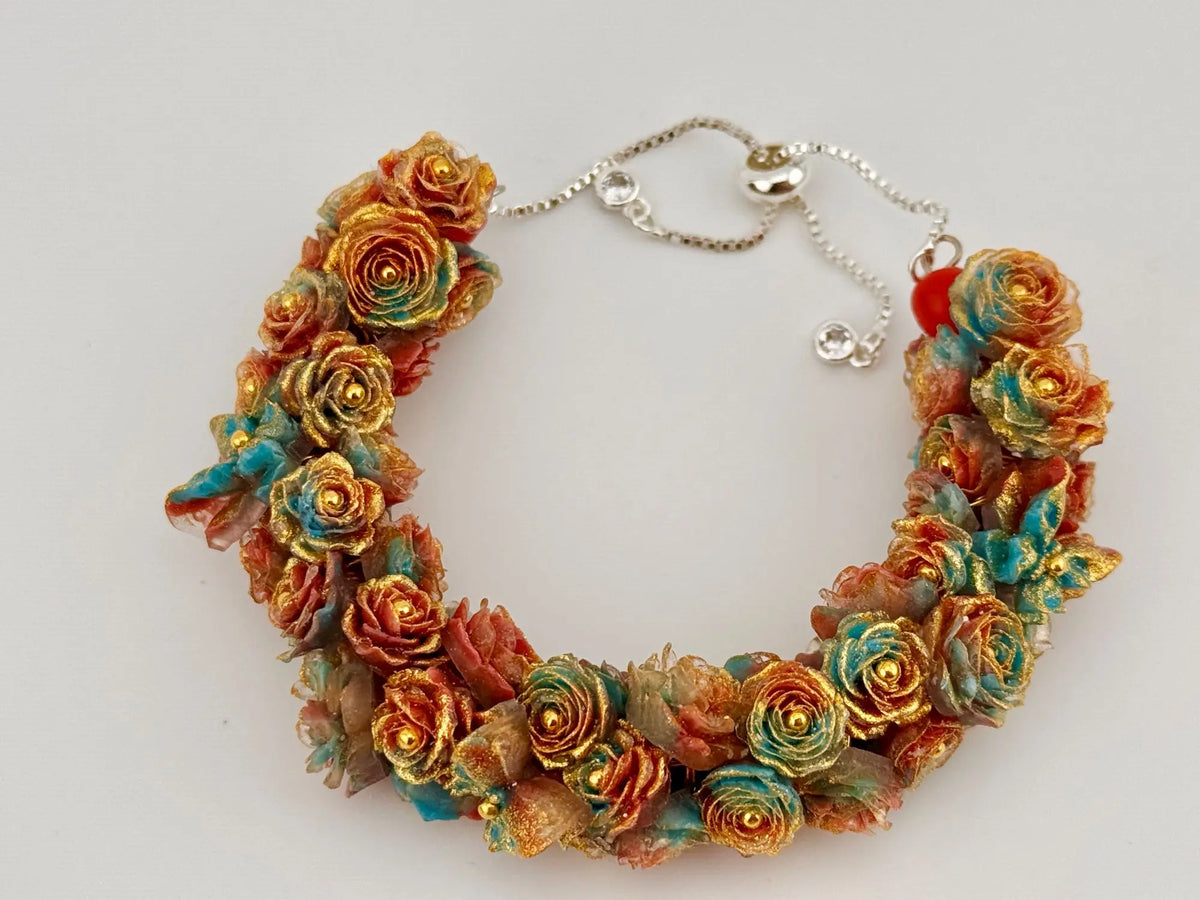 Elegantes Damenarmband mit bunten Blumen-Details, goldenen Akzenten und verstellbarer Kette als DIY Schmuck Geschenkidee.