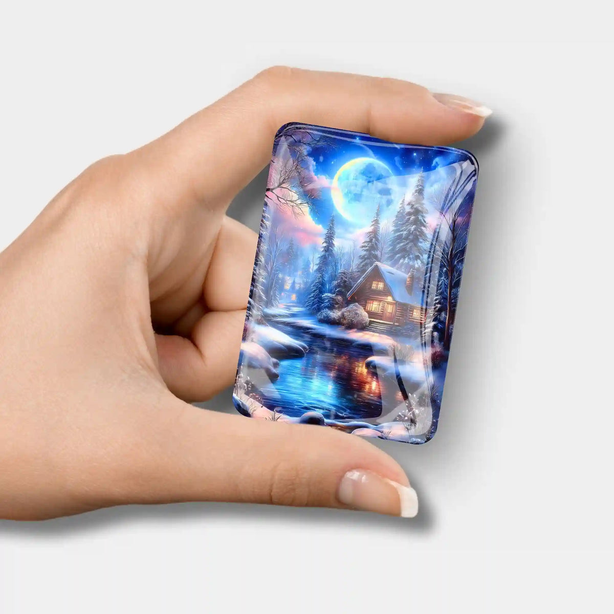 Glas Cover Minder für Diamond Painting mit Winterlandschaft Motiv Zuflucht im Silberlicht in einer Hand gehalten.