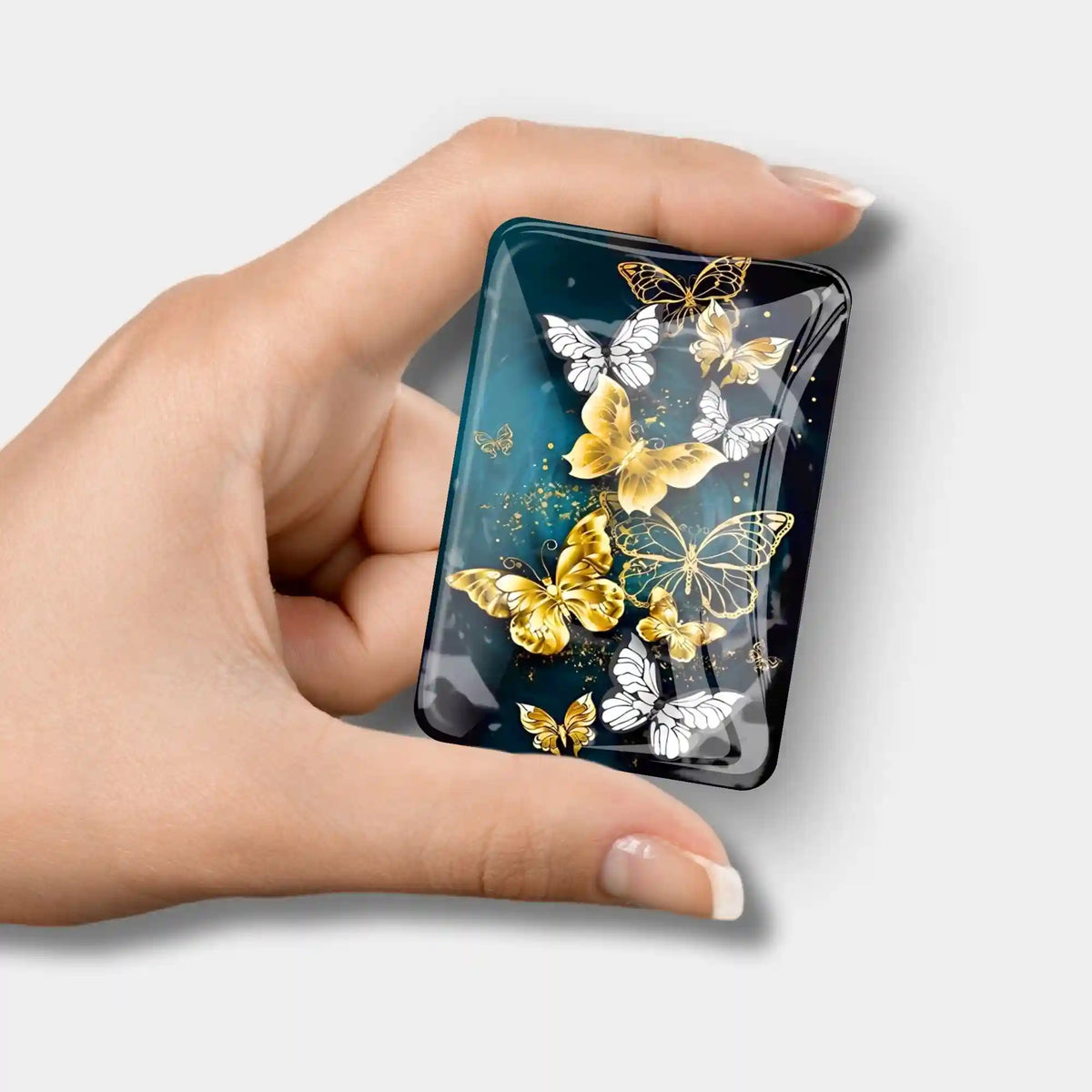Diamond Painting Cover Minder mit goldenen Schmetterlingen auf dunkelblauem Glas zur Fixierung der Schutzfolie
