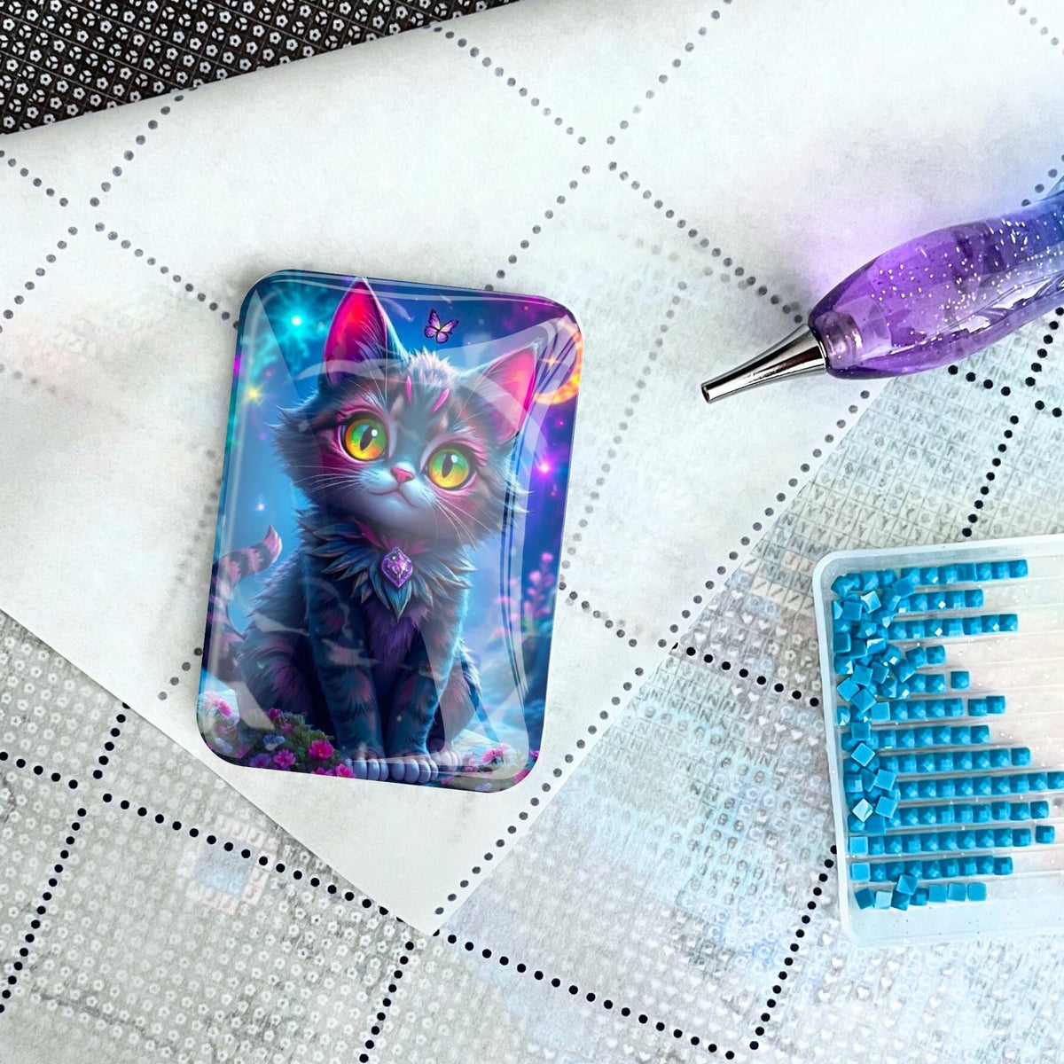 Diamond Painting Cover Minder Night Cat auf Leinwand neben Stift und blauen Diamanten für dein nächstes Bastelprojekt