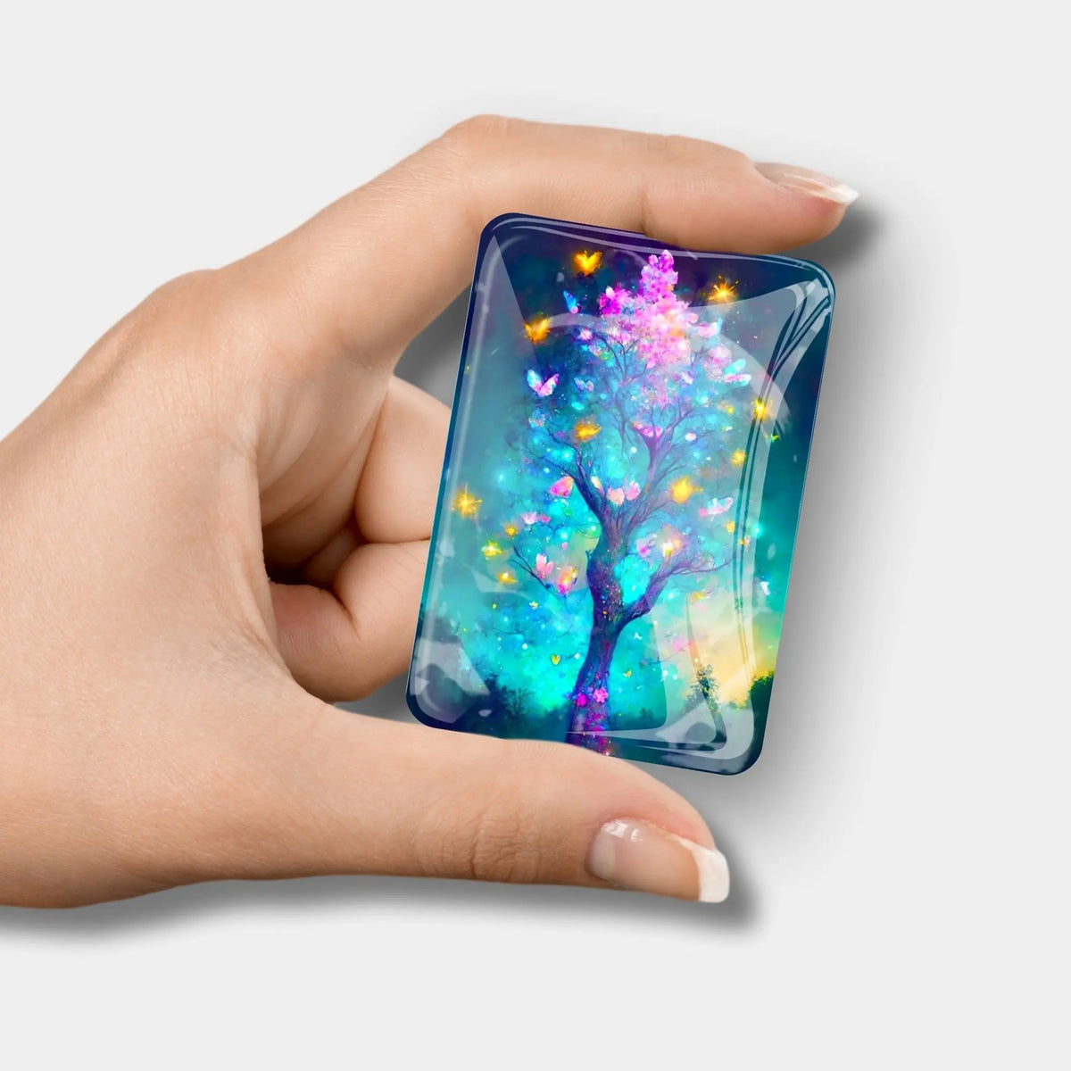 Glas Cover Minder mit Schmetterlingsbaum Motiv als praktisches Diamond Painting Zubehör in einer Hand gehalten.