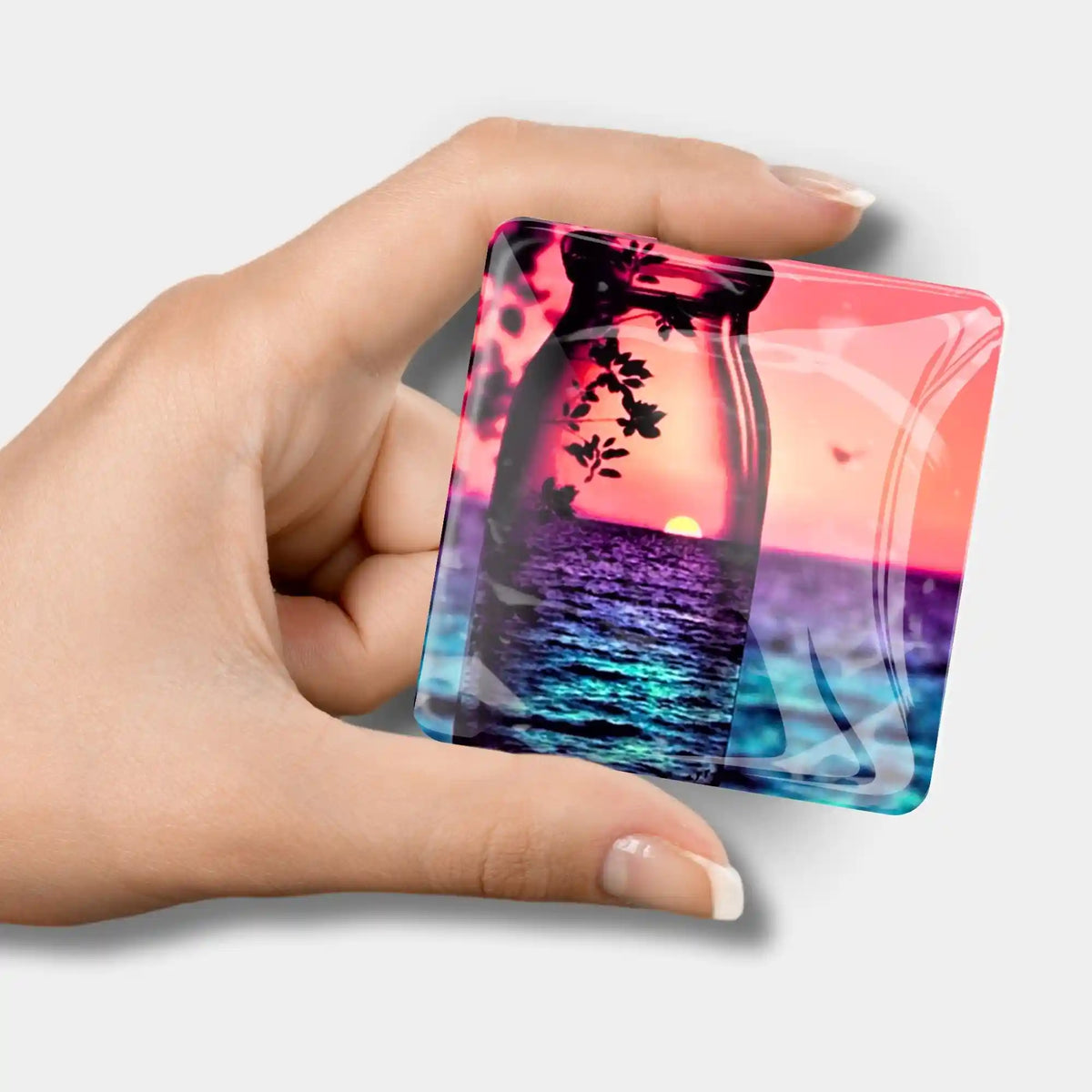 Quadratischer Diamond Painting Cover Minder mit Motiv Roter Sonnenuntergang in einer Hand für praktisches Bastel-Zubehör.