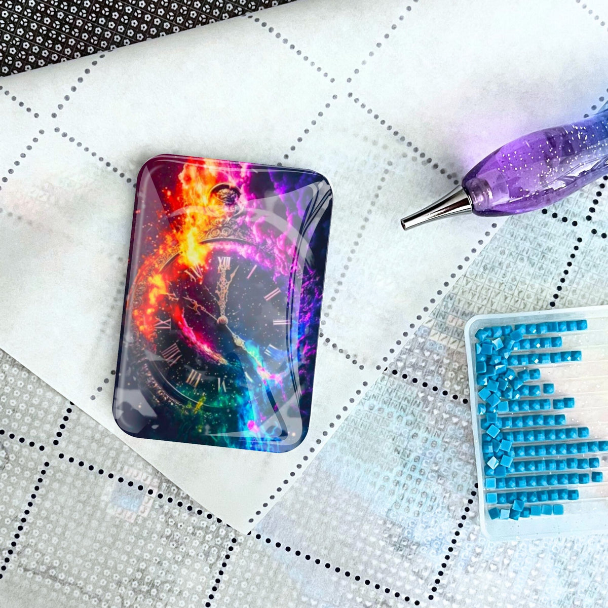 Magischer Coverminder mit Uhr-Motiv für Diamond Painting, platziert auf Leinwand mit Glitzersteinen und Diamond Artist Stift