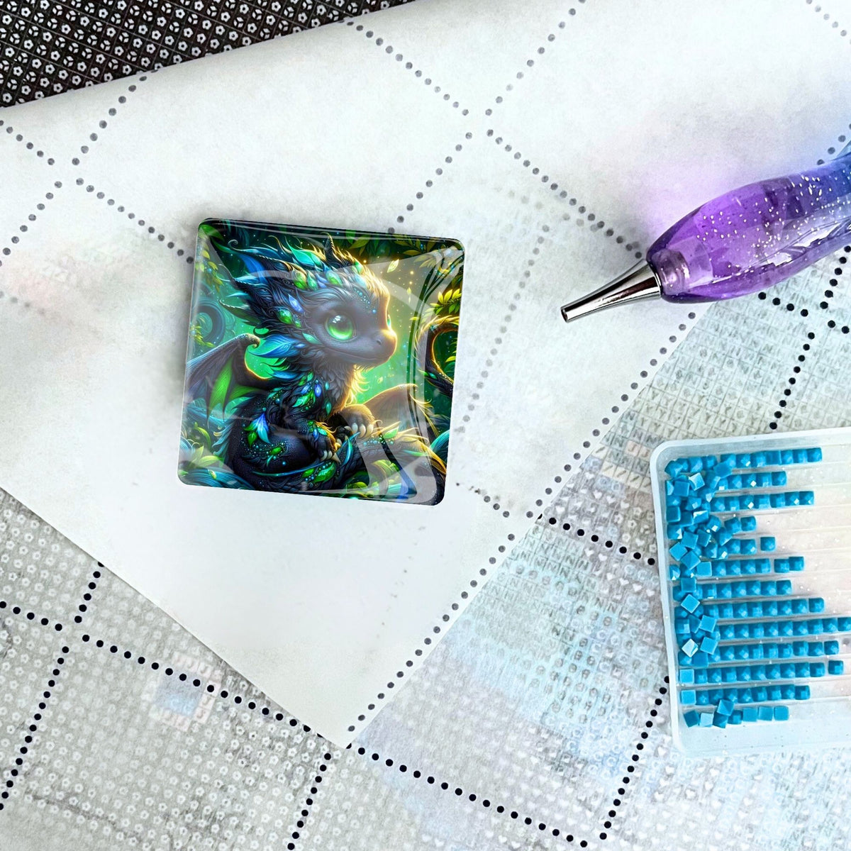 Cover Minder mit Drachen-Motiv auf einer Diamond Painting Leinwand mit Stift und blauen Steinchen