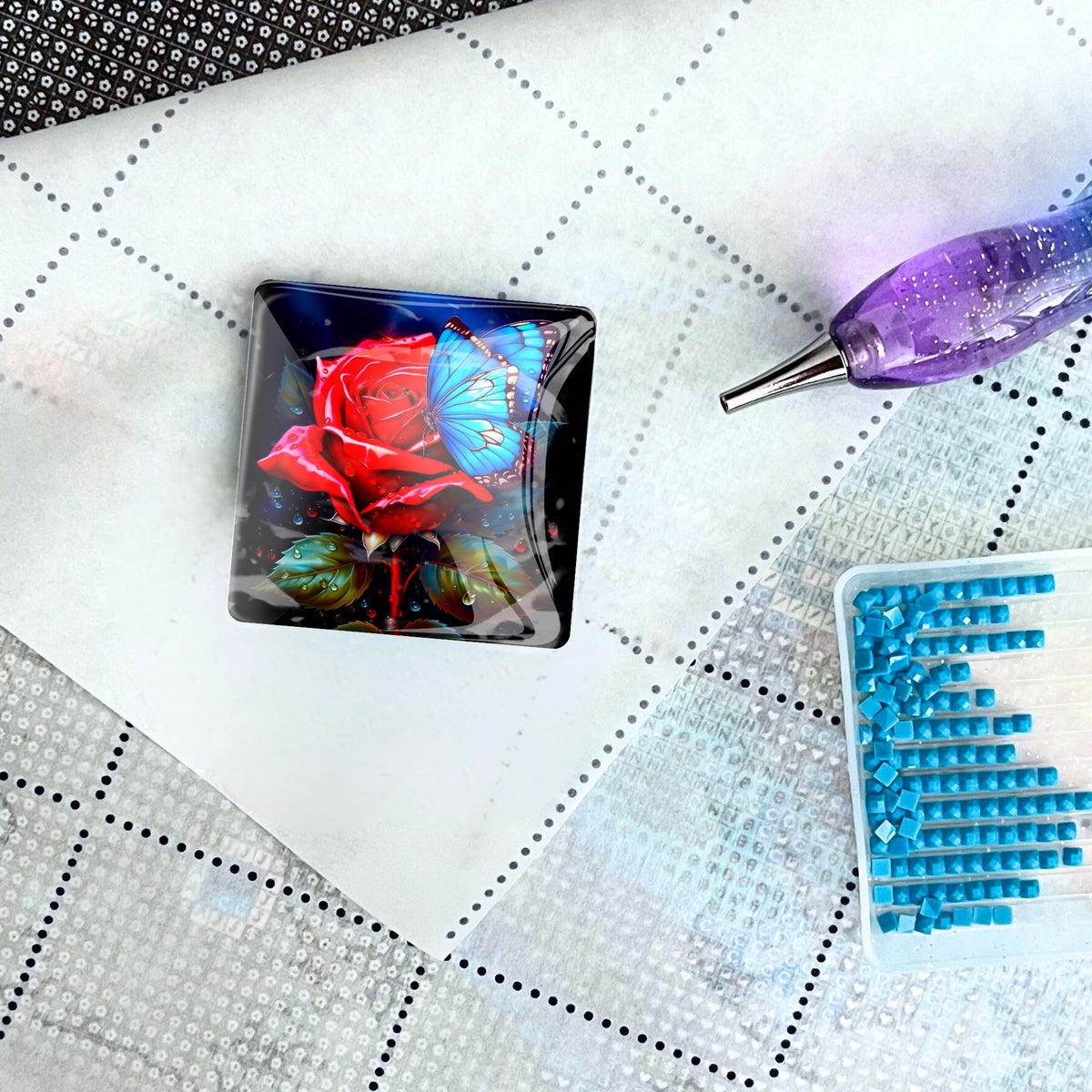 Glas Cover Minder mit roter Rose und blauem Schmetterling als praktisches Zubehör für dein Diamond Painting Set.