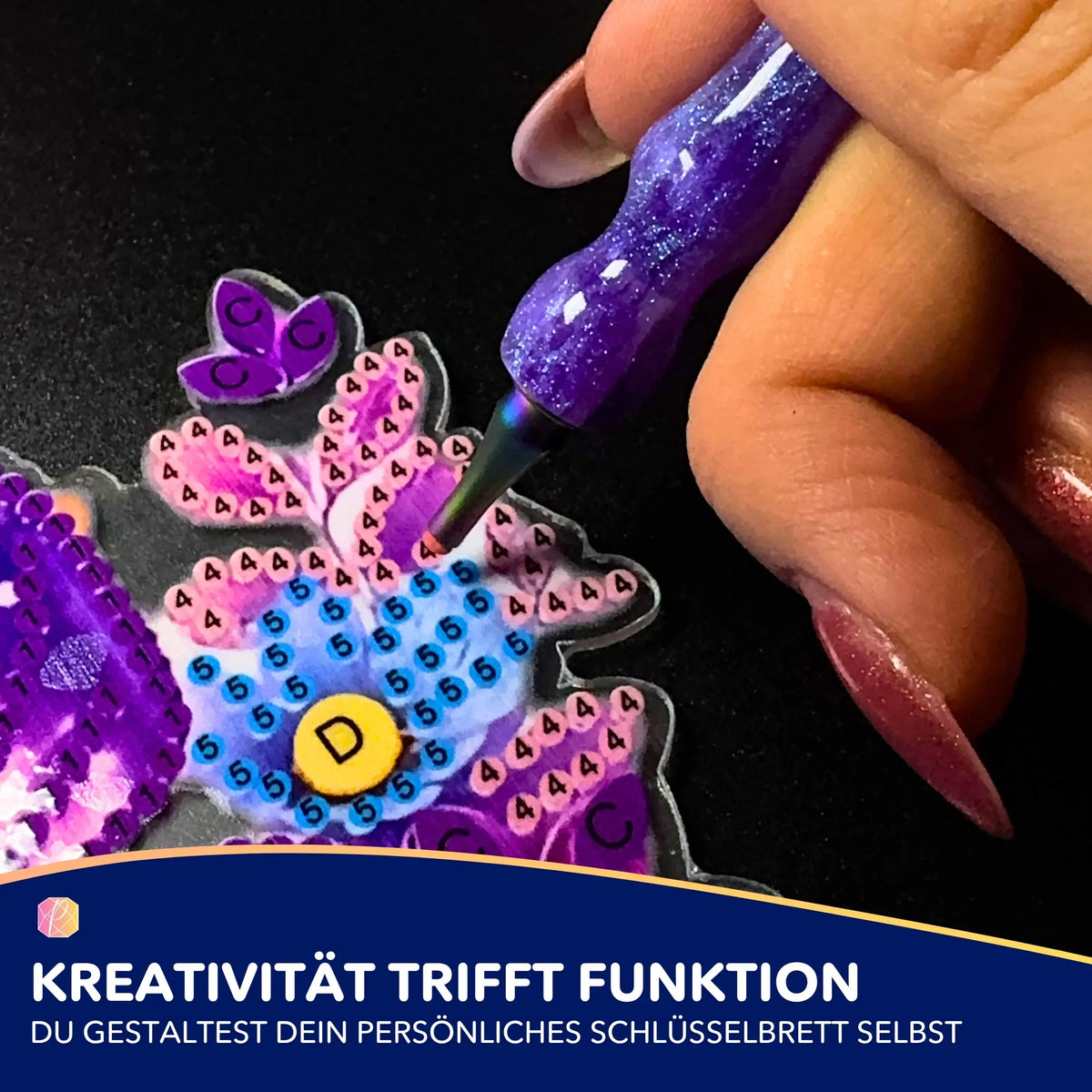 Diamond Painting Schlüsselbrett DIY-Set mit Schmetterlingsmotiv und lila Glitzer-Stift beim Aufsetzen der Steine